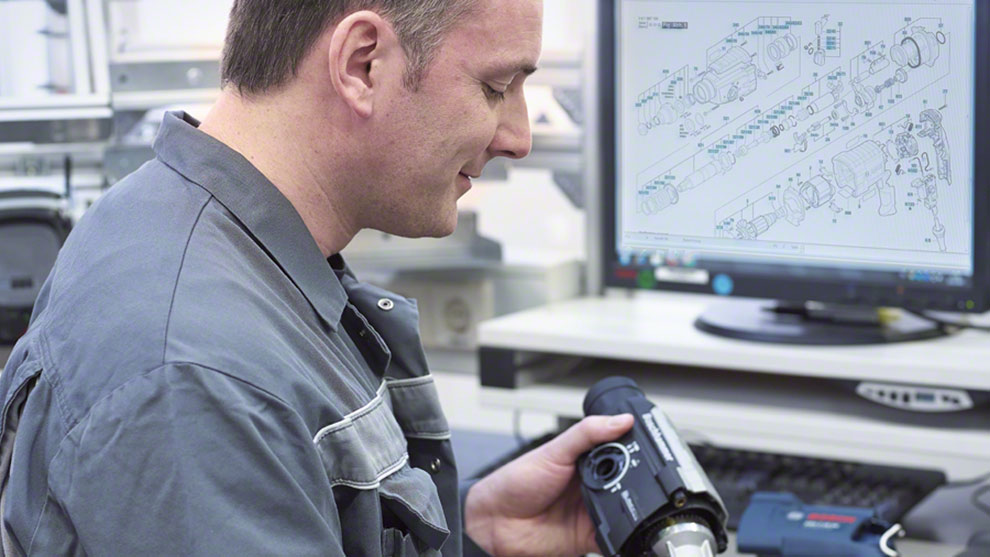 一名穿着工作服的男子正在查看博世专业工具。