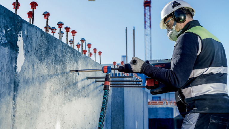 一名工人在工地上使用博世工具处理混凝土墙。