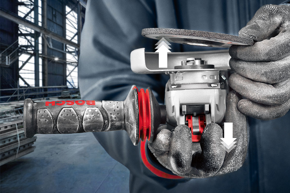 两只手在车间里握着博世专业磨光机。